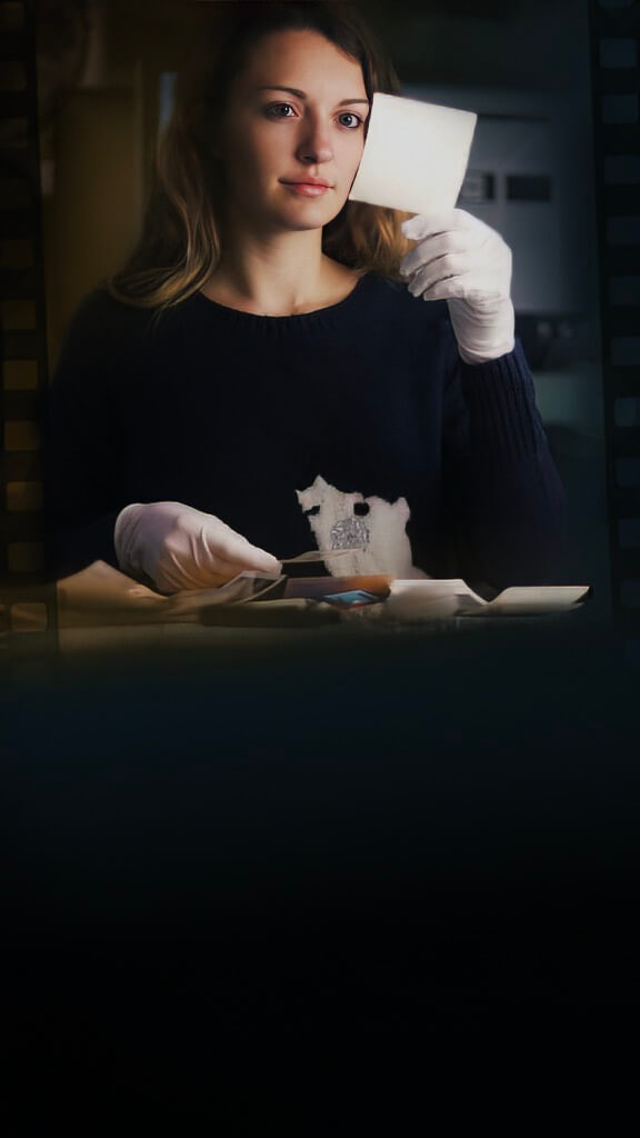 Manager gently holding a faded old family photograph, symbolizing memory preservation through digitization